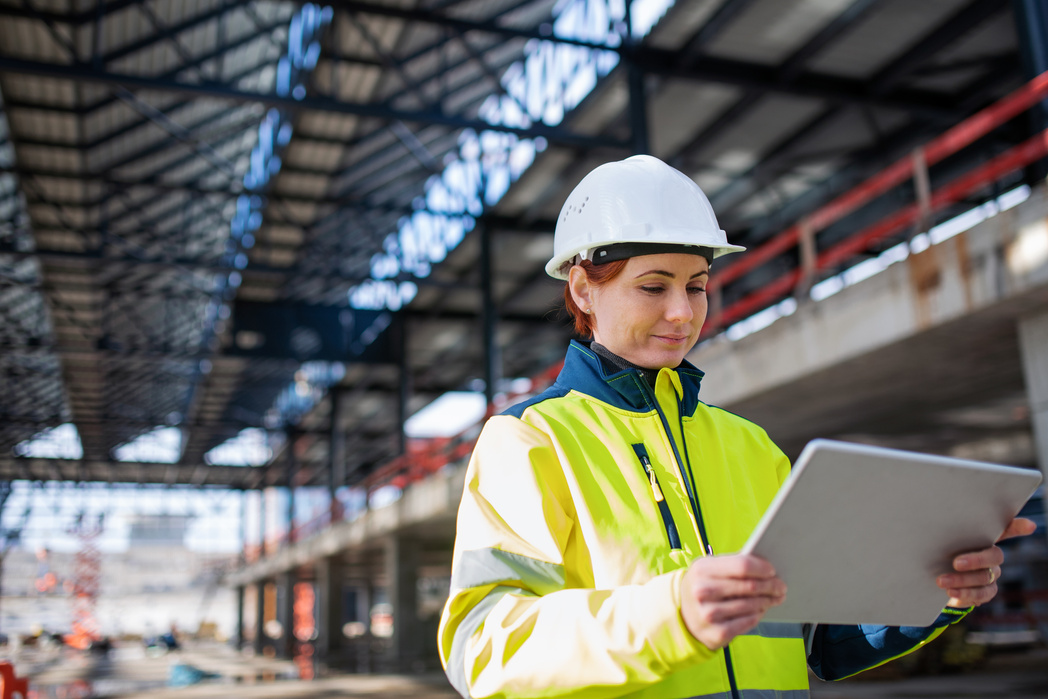 Woman Engineer with Tablet Standing on Construction Site